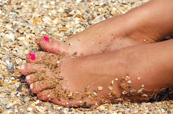 砂利と砂のビーチで女性の足 — ストック写真