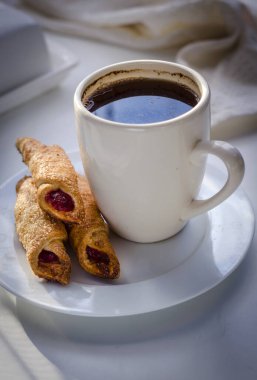 Beyaz arka planda reçelli kahve ve bisküvi.