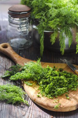 Mutfak tahtasının üzerinde dilimlenmiş taze dereotu. Taze kesilmiş yeşiller