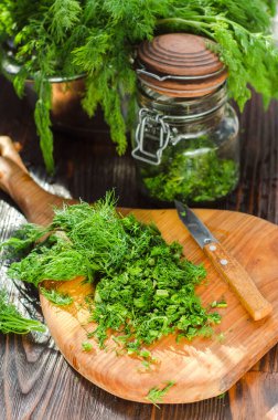Mutfak tahtasının üzerinde dilimlenmiş taze dereotu. Taze kesilmiş yeşiller
