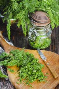 Mutfak tahtasının üzerinde dilimlenmiş taze dereotu. Taze kesilmiş yeşiller