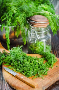 Mutfak tahtasının üzerinde dilimlenmiş taze dereotu. Taze kesilmiş yeşiller