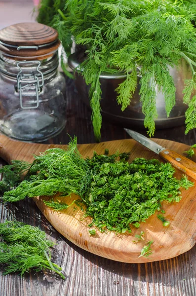 Mutfak tahtasının üzerinde dilimlenmiş taze dereotu. Taze kesilmiş yeşiller