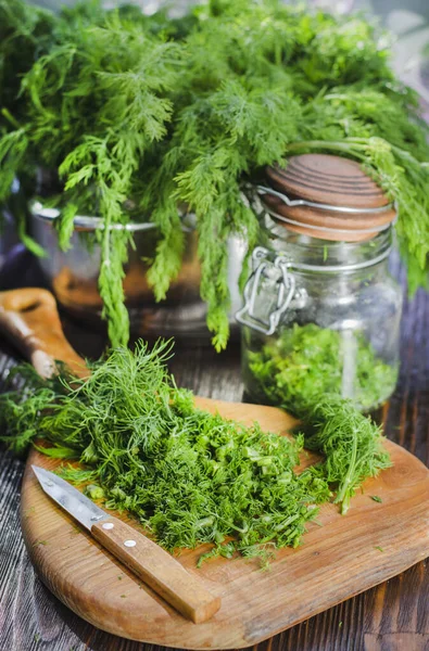 Mutfak tahtasının üzerinde dilimlenmiş taze dereotu. Taze kesilmiş yeşiller