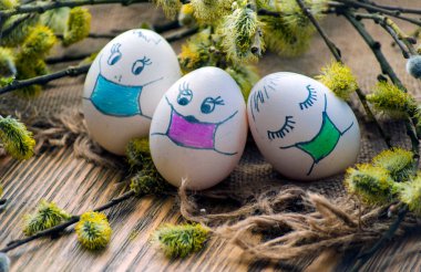 Paskalya için söğüt dalları arasında maskeli boyanmış yumurtalar