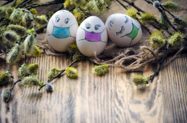 Paskalya için söğüt dalları arasında maskeli boyanmış yumurtalar