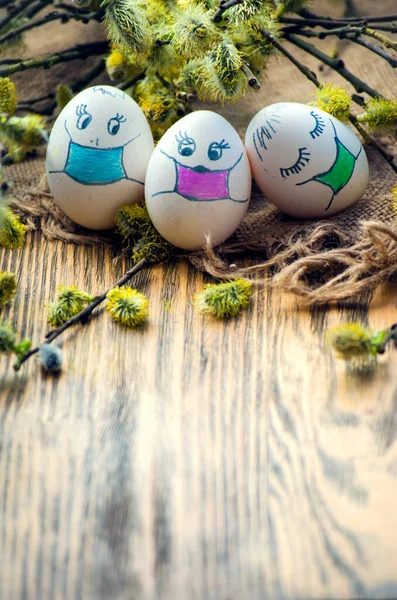Paskalya için söğüt dalları arasında maskeli boyanmış yumurtalar