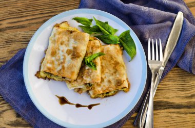 Kızarmış lavaş rulosu, süzme peynir, ıspanak ve otlar tabakta.