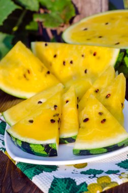 Sarı posalı karpuz. Tahta bir masada dilimlenmiş böğürtlen parçaları..