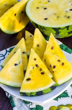 Sarı posalı karpuz. Tahta bir masada dilimlenmiş böğürtlen parçaları..