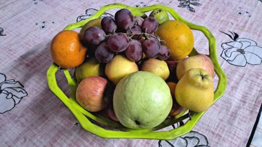 Beyaz arka planda bir sepet dolusu renkli taze meyve..