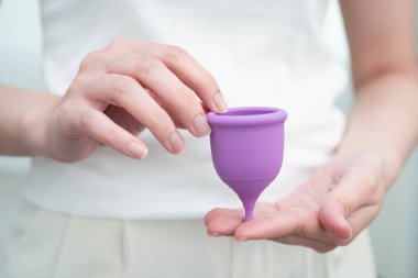 Hijyen dönemi koruması için elinde regl fincanı tutan Asyalı kadın..