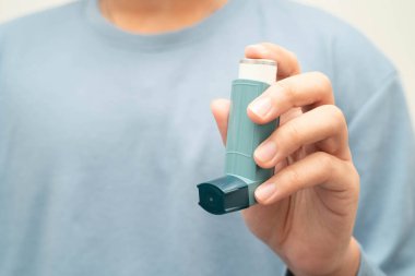 Astım ve kronik obstrüktif akciğer hastalığı KOAH, Asyalı genç ölçülü doz solunum cihazı kullanıyor..