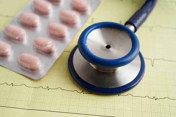 Стетоскоп на электрокардиограмме ЭКГ с капсульным препаратом, сердечная волна, сердечный приступ, отчет кардиограммы.