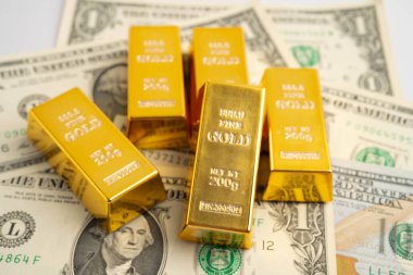 Gold bars on US dollar banknote money, finance trading investment business currency concept.