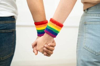 Gökkuşağı bilekliği takan Asyalı LGBT çifti..