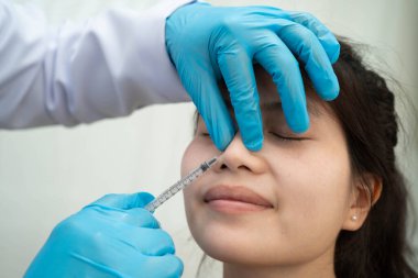 Yüzüne estetik ameliyat şeklinde estetik ameliyat yaptıran Asyalı bir kadın..