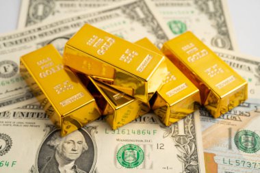 Gold bars on US dollar banknote money, finance trading investment business currency concept.