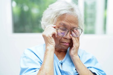 Bangkok, Tayland 15 Mart 2023 Asyalı gözlüklü son sınıf öğrencisi baş ağrısını ve göz ağrısını azaltıyor..