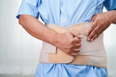 Esnek destek kemeri takan Asyalı son sınıf öğrencisi sırt ağrısını azaltabilir..