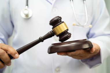 Asyalı doktor, adli tıp ve suç hukuku için çekiç tutuyor..