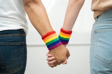 Gökkuşağı bilekliği takan Asyalı LGBT çifti..