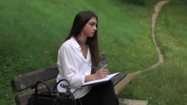 Girl draws on the bench — Stock Video