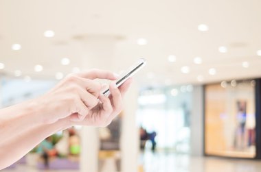 Akıllı telefon alışveriş arka plan üzerinde tutan el