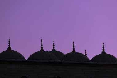 Minarets silhouettes on purple sky clipart