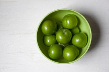 Green plums in green bowl clipart