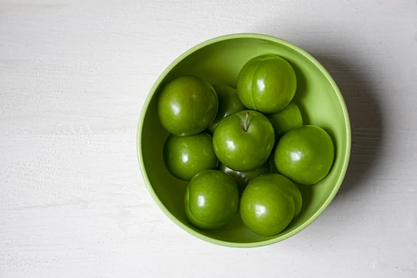 Ciruelas verdes en tazón verde —  Fotos de Stock