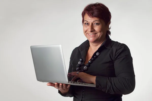 Зріла жінка тримає ноутбук — стокове фото