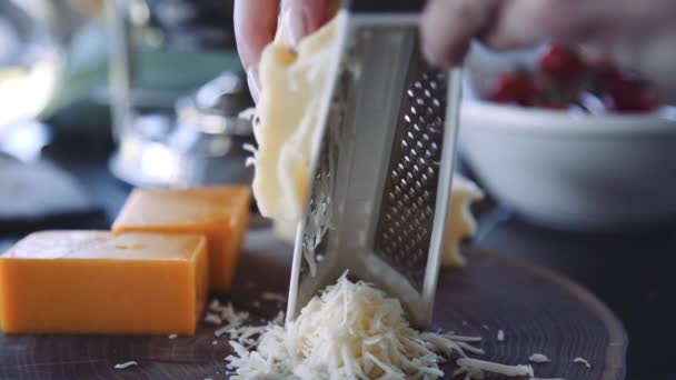 Vrouwelijke chef raspt de kaas op een rasp in slow motion — Stockvideo