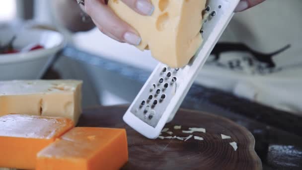 Chef femelle râpe le fromage sur une râpe au ralenti — Video