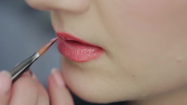 Maquillaje artista pinta los labios de modelo con lápiz labial — Vídeo de stock