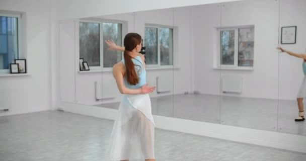 Χορευτής ζεσταίνει infromt του καθρέφτη τοίχο στο λευκό φωτεινό αίθουσα χορού πριν από την πρόβα, πρόβα μπαλέτου, μπαλαρίνα στο στούντιο μπαλέτου, μάθημα αίθουσα χορού, 4k 60p Prores HQ — Αρχείο Βίντεο