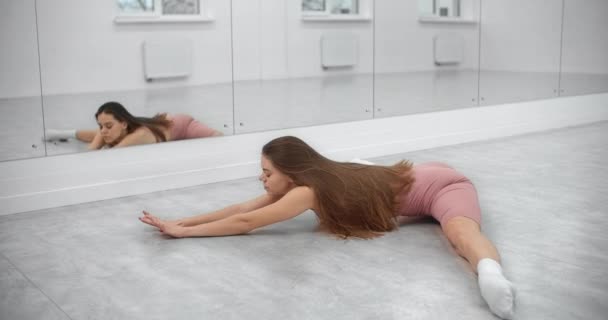 Dancer is sitting on the twine and warming up infront of the mirror wall in the white bright dance hall, ballet rehearsal, ballerina in the ballet studio, dance hall lesson, 4k 60p Prores HQ — Stock Footage Dancer is sitting on the twine and warming up infront of the mirror wall in the white bright dance hall, ballet rehearsal, ballerina in the ballet studio, dance hall lesson, 4k 60p Prores HQ Royalty Free Stock Video