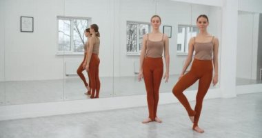 İki genç dansçı gösterilerini beyaz dans salonunda prova ediyorlar, bale provası, bale stüdyosunda balerinler, dans dersi, dans salonu düeti, 4k 60p Prores HQ