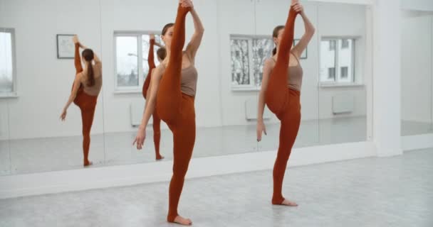Dwóch młodych tancerzy ćwiczy swój występ w białej jasnej sali tanecznej, próbę baletu, baletnice w studiu baletowym, lekcję tańca, duet taneczny, 4k 60p Prores HQ — Wideo stockowe