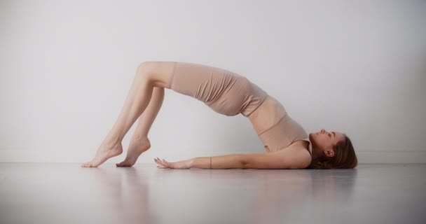 Yoga eğitmeni yavaş çekimde esneme egzersizleri yapıyor, sıkı vücut kıvrımlı jimnastik kadın beyaz arka planda pilates ve yoga egzersizleri yapıyor, 4k 120p Prores karargahı. — Stok video