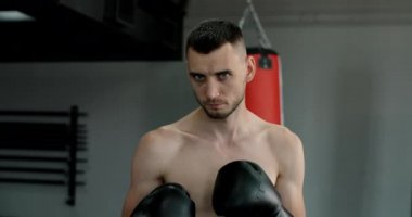 Dövüş pozisyonunda duran kickboksörün portresi, MMA dövüşçüsü antrenmanda, 4k 60p Prores HQ