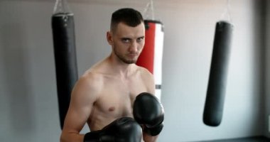 Steadicam shot: Dövüş pozisyonunda duran kickboksörün portresi, MMA dövüşçüsü antrenmanda, 4k 60p Prores HQ