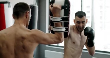 Kickboksör ağır çekimde döner tekme atar, kickboksörler spor salonunda antrenman yapar, 4k 120 fps Prores karargahında