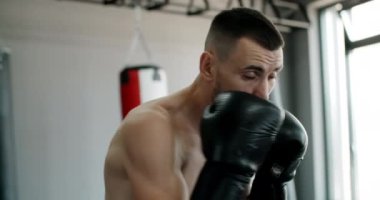 Boks eldivenli kickboksör boks kulübünde gölge boksu yapar ve antrenman yapar. Dövüşçü gölgelerle dövüşür. Spor salonunda kickboksör eğitim grevleri yapar.