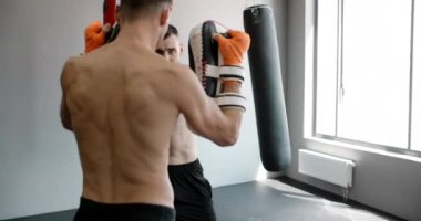 Steadicam shot: Kickboxer orta vuruşunu spor salonunda ağır çekimde çalıştırıyor, kickboksör antrenman yapıyor, 4k 120fps Prores HQ