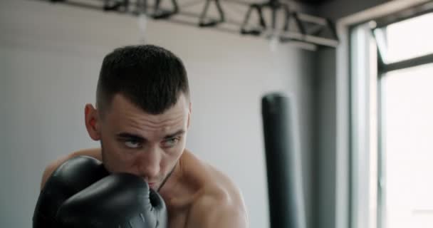 Kickboxer en guantes de boxeo hace boxeo en la sombra y entrena en el club de boxeo, el hombre luchador está luchando con la sombra, kickboxer golpes de entrenamiento en el gimnasio, 4k 60p HQ de Prores — Vídeos de Stock