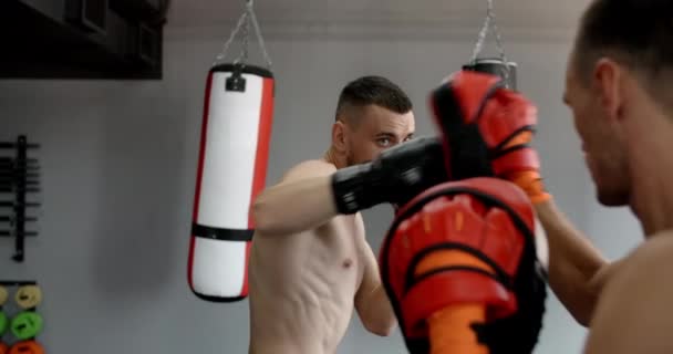 Combatiente en guantes de boxeador está practicando sus golpes con entrenador en cámara lenta en el gimnasio, kickboxers están entrenando, 4k 120fps HQ de Prores — Vídeo de stock