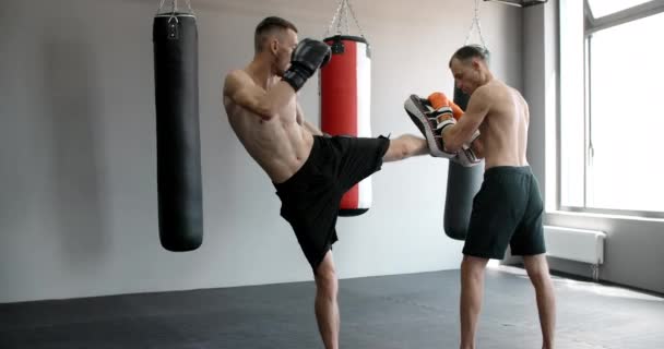 El kickboxer está practicando su patada intermedia con entrenador en cámara lenta en el gimnasio, luchador de artes marciales mixtas está entrenando, 4k 120fps HQ de Prores — Vídeos de Stock