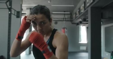Karışık dövüş sanatları dövüşçüsü kadın dövüş kulübünde kameraya gölge boksu yapıyor, kadın dövüşçü gölgelerle dövüşüyor, kickboksör eğitim grevleri spor salonunda, 4k 120fps Prores genel merkezi