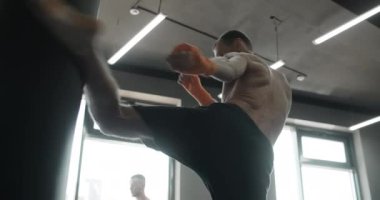 Kickboksör boksör boksör çantasına ağır çekimde tekme atıyor, boks kulübünde antrenman yapıyor, 4k DCI 120p Prores karargahında.